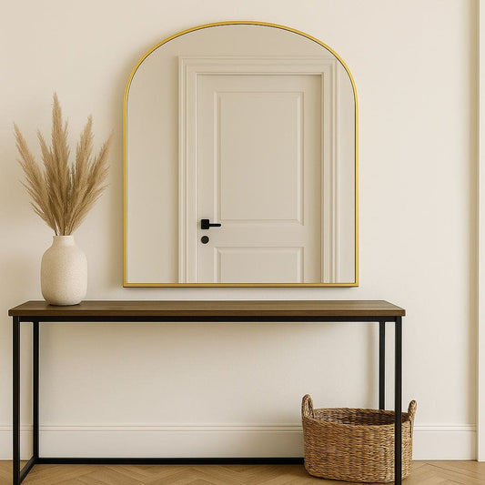 Yoko - Gold Metal Gentle Arch Mirror - 120cm x 95cm above a table with a vase and a basket.