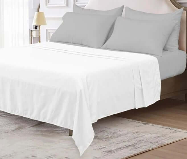 Luxury Flat Sheet - Organic Cotton on a bed with grey pillows and a stylish room decor.