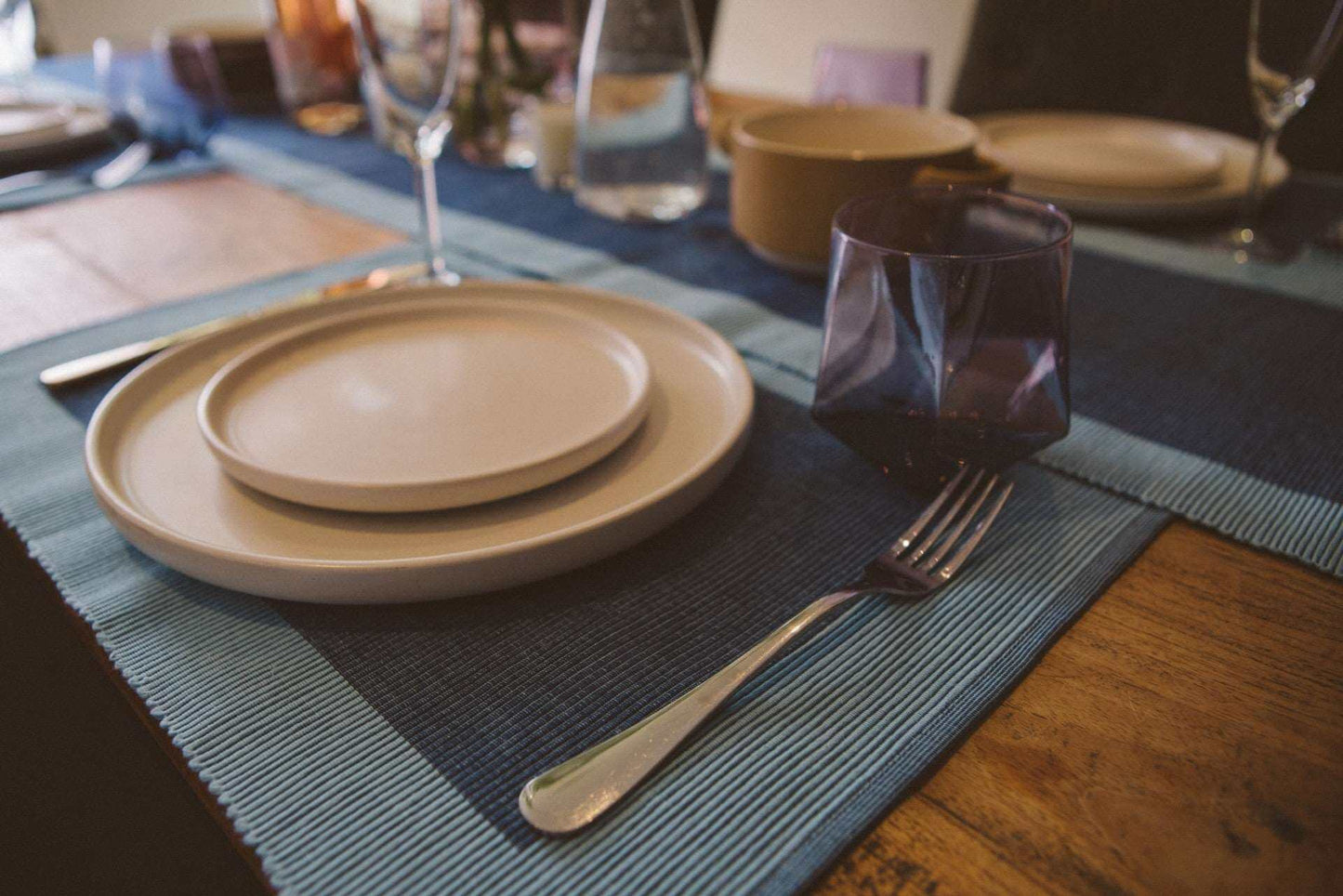 Luxury Placemats Blue - 4 Pack displayed on a wooden table with elegant dishware and glassware.
