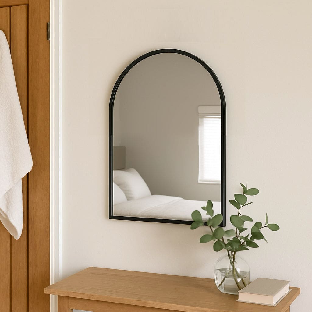 Akiko - Black Metal Arched Mirror - 70cm x 50cm mounted on a wall, showcasing modern aesthetic and minimal design.