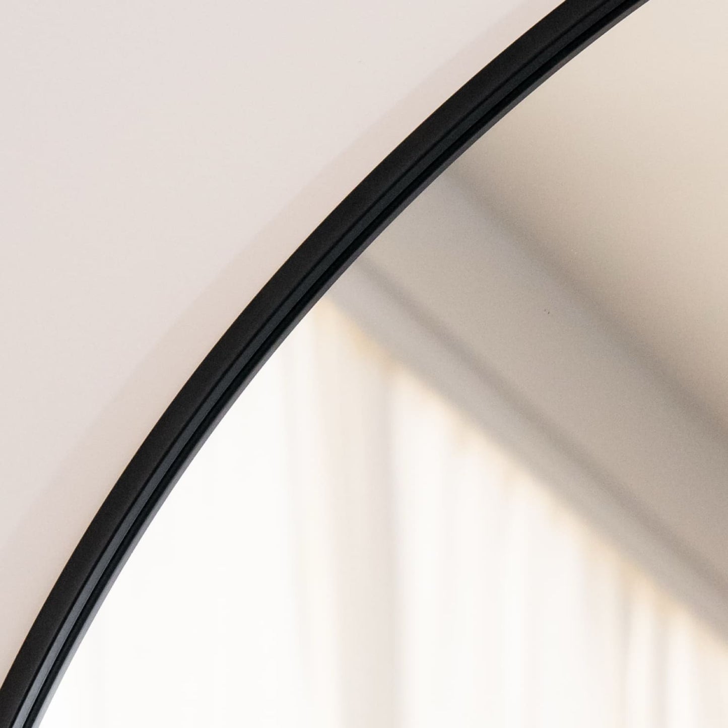Akiko - Black Metal Arched Mirror - 70cm x 50cm close-up of curved black frame and reflective surface.
