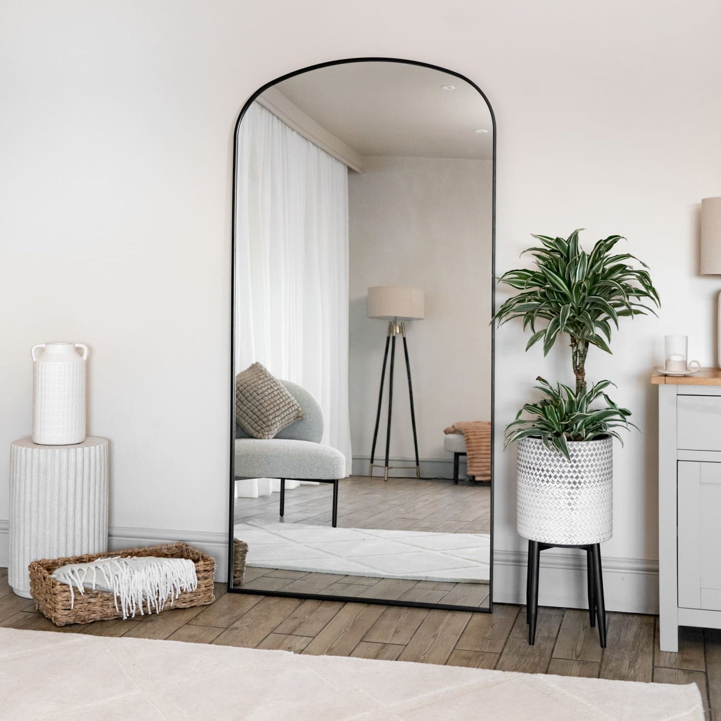 Yoko - Full Length Black Metal Gentle Arch Mirror - 180cm x 90cm placed in an elegant interior setting with plants.